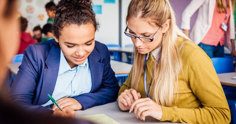 Two students working together on a laptop